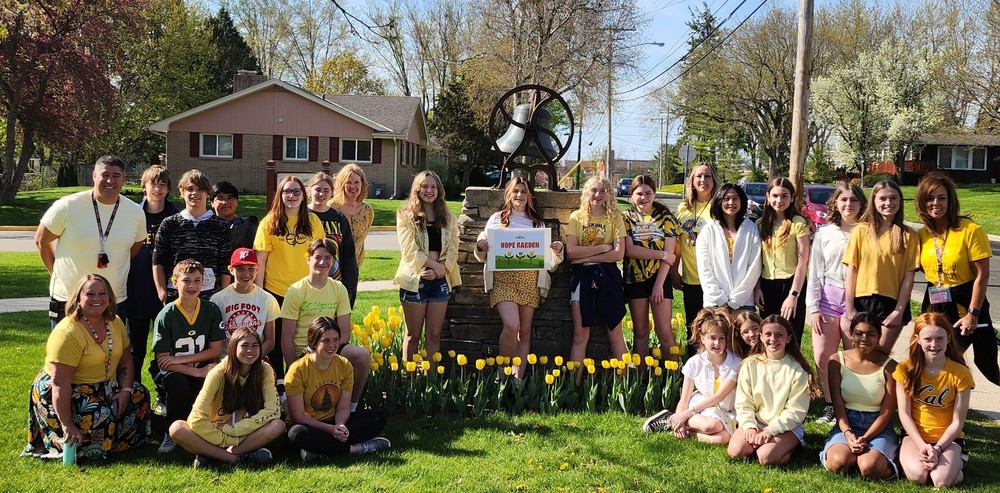 Group of students with staff around yellow tulips