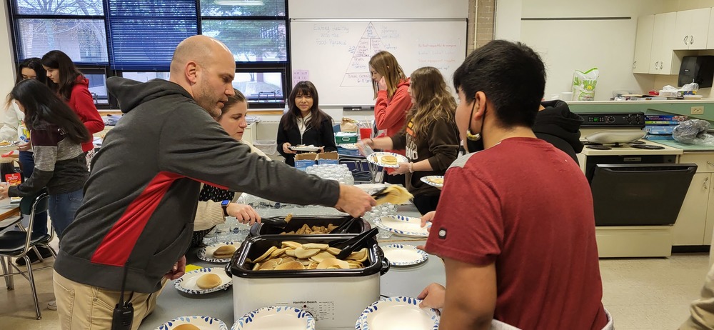Food being served to 8th grade students by staff